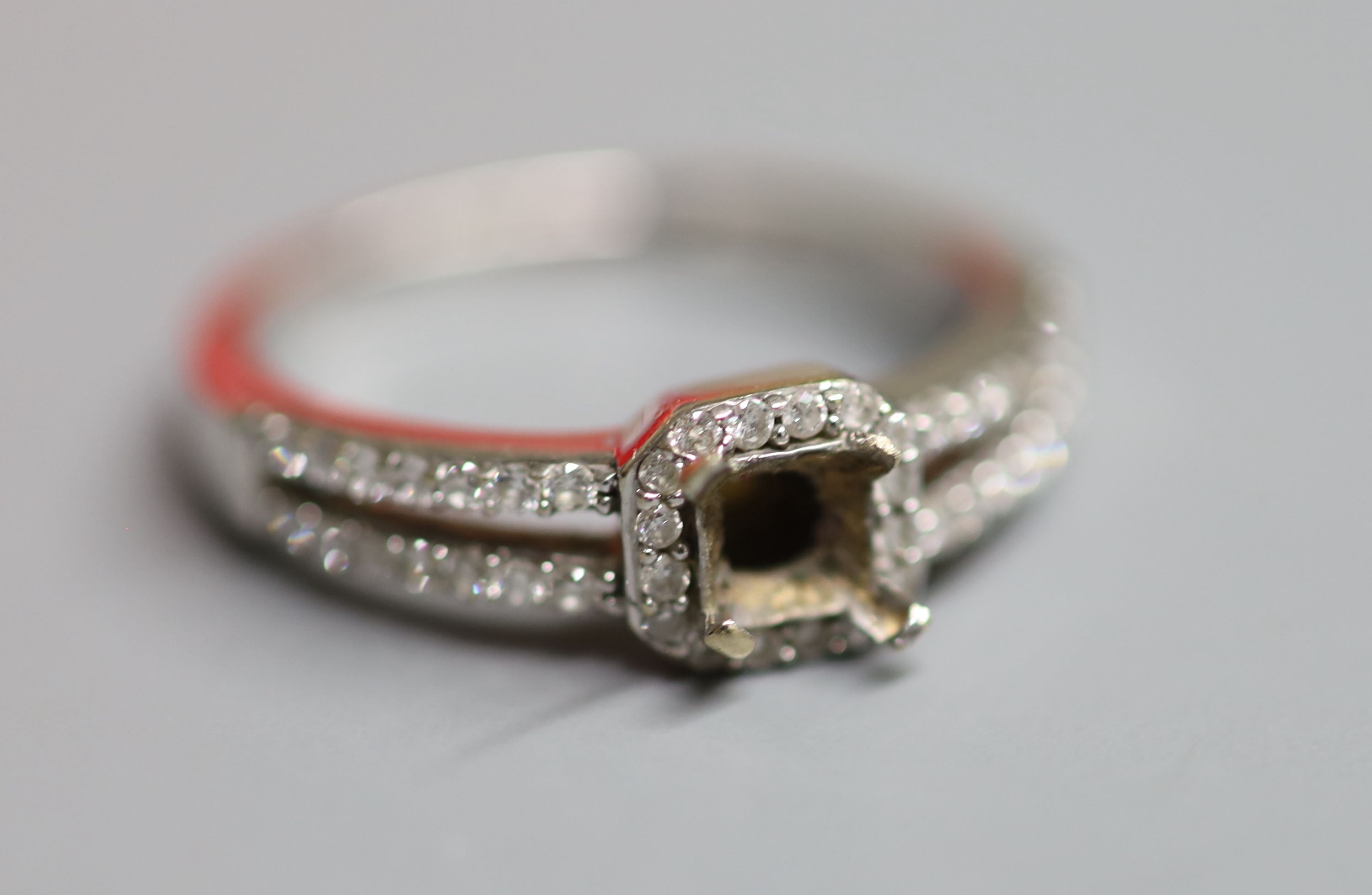 A modern 18ct white gold and diamond chip set dress ring(centre stone missing), with diamond set shoulders(stone missing)